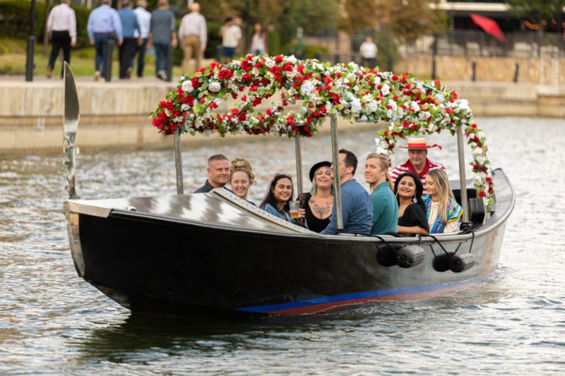 folks riding in a flower covered gondola in irving, texas