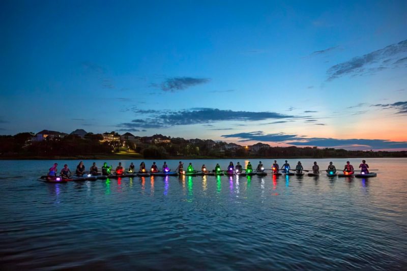 an array of multicolored paddleboards on the wate r